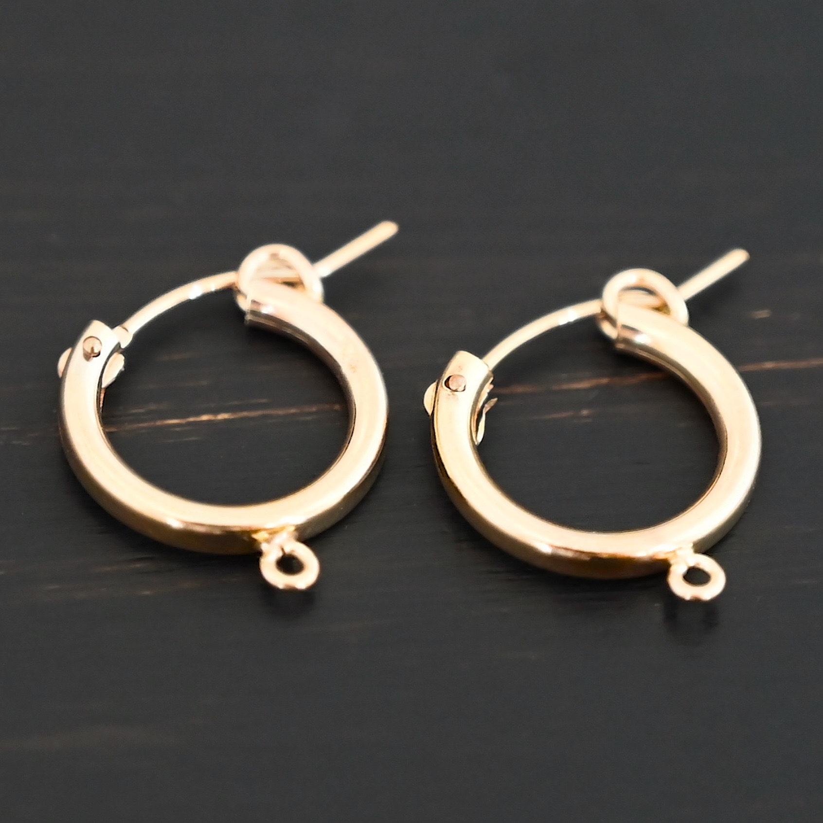 West 14k gold filled hoops shown on dark background