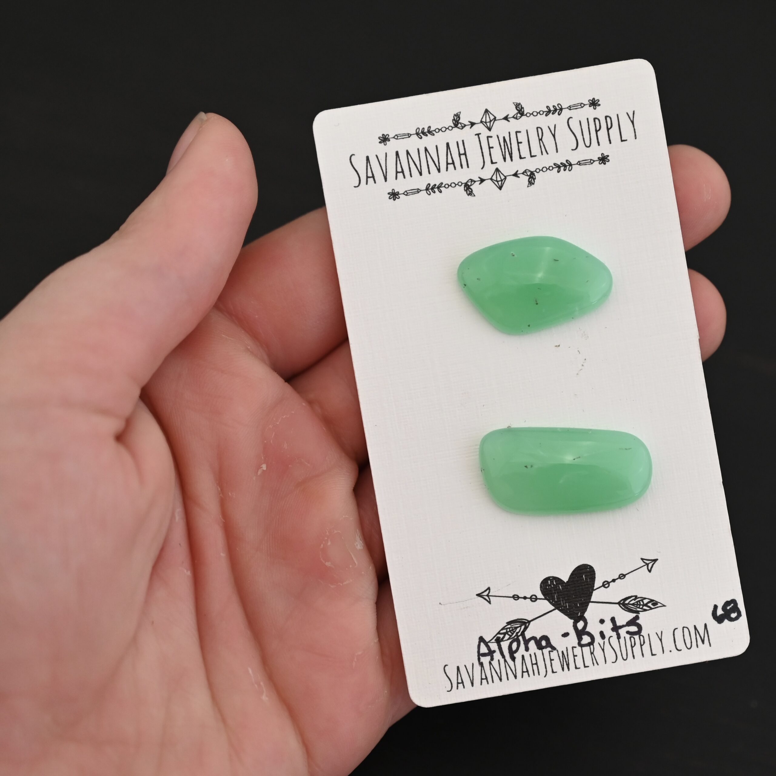 Alpha-Bits Chrysoprase Cabochon Parcel shown in hand