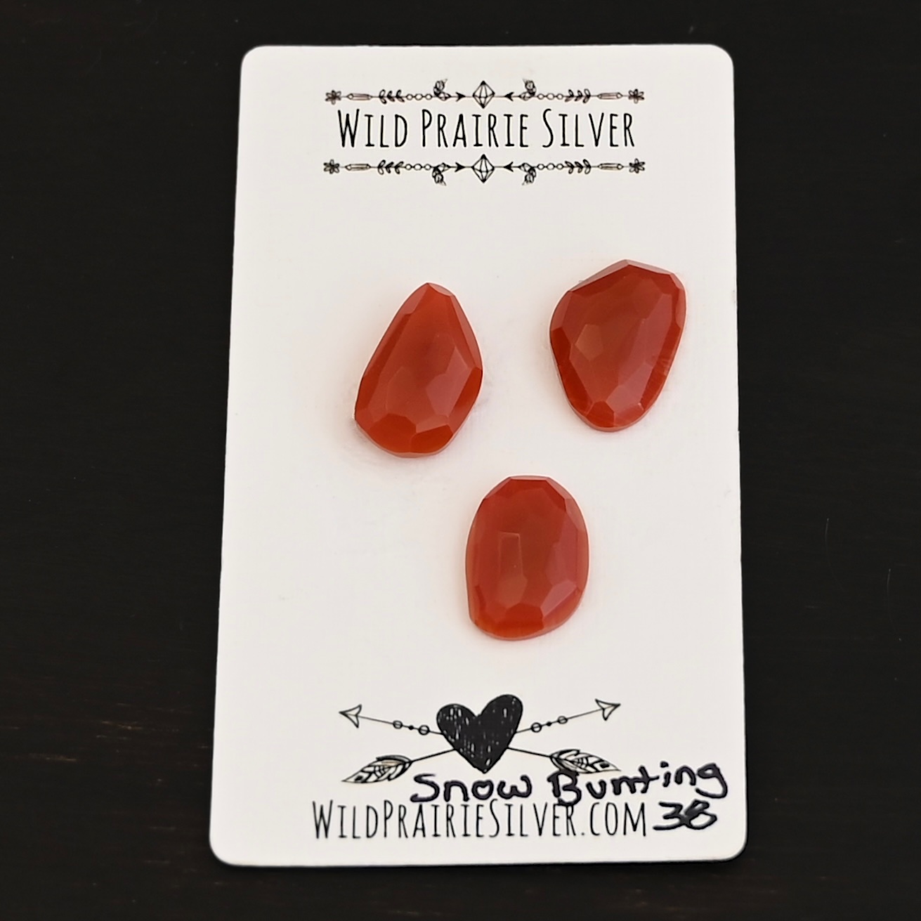 Snow Bunting Rose Cut Carnelian Cabochon Parcel shown on business card