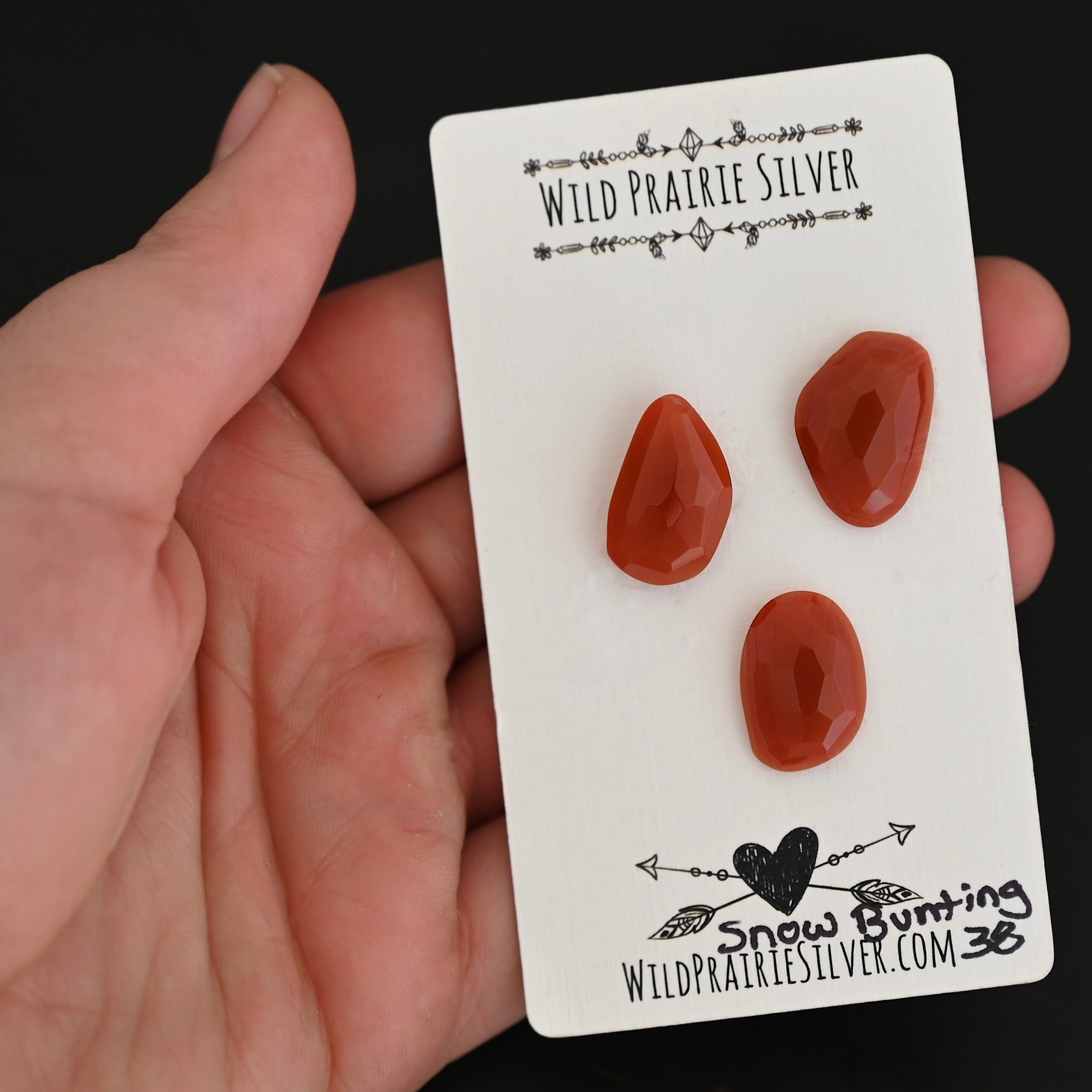 Snow Bunting Rose Cut Carnelian Cabochon Parcel shown in hand