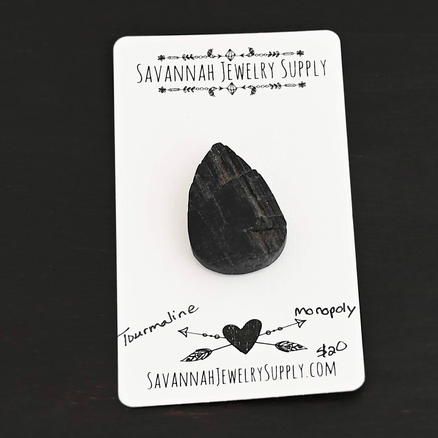 Monopoly Tourmaline Cabochon shown on business card