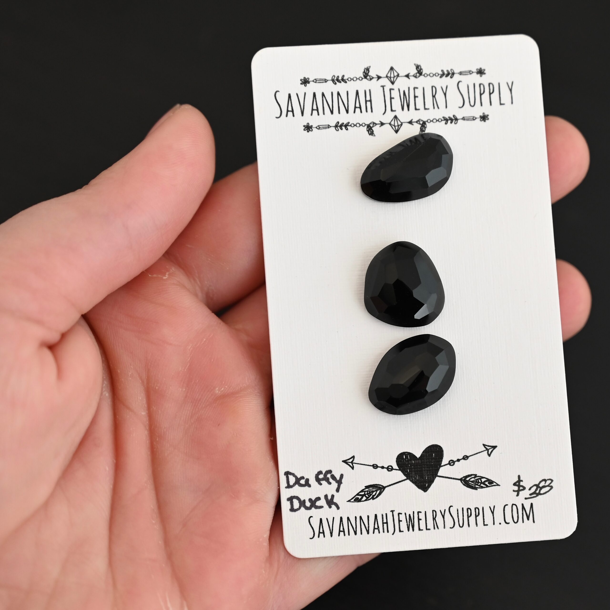 Daffy Duck Black Onyx Cabochon Parcel shown in hand