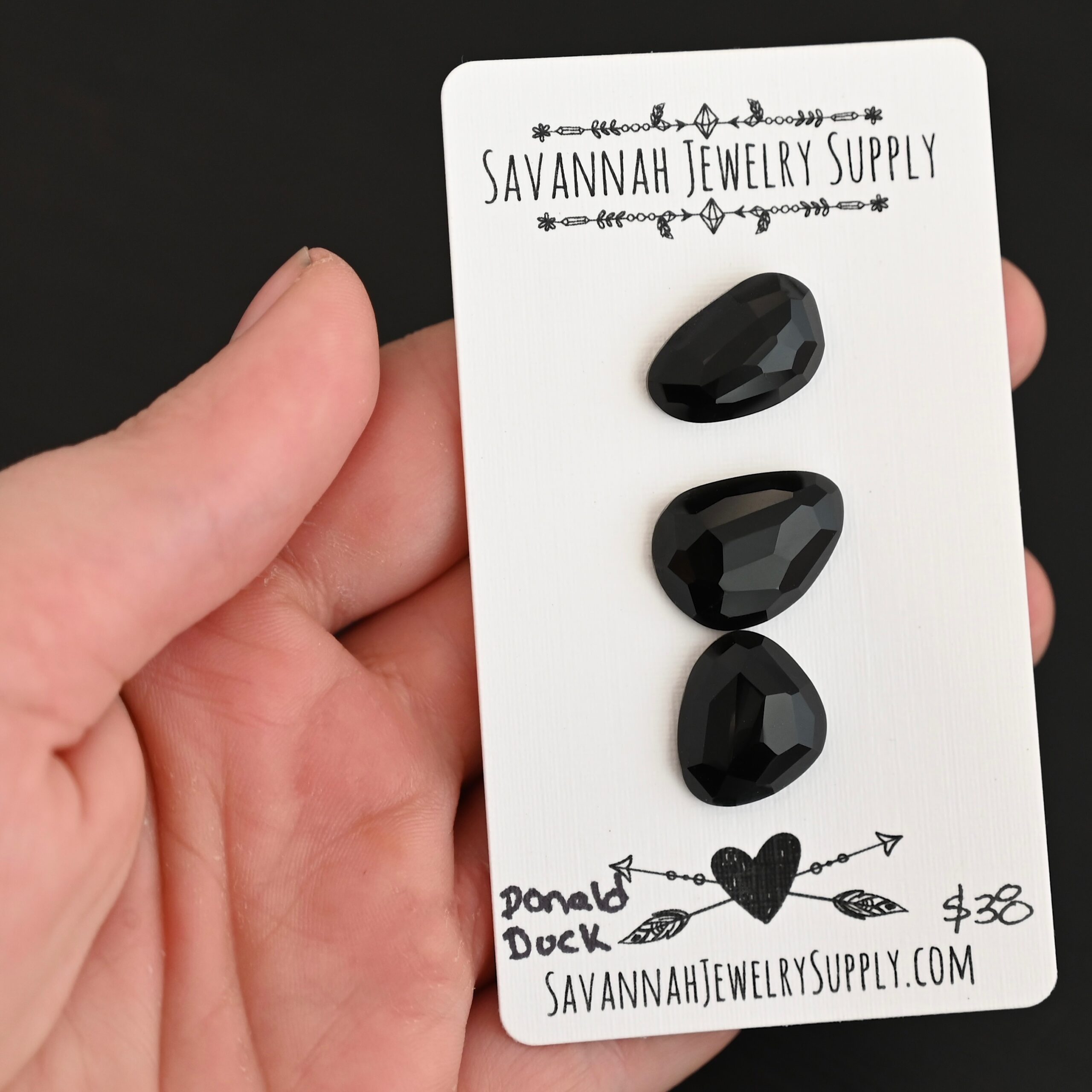 Donald Duck Black Onyx Cabochon Parcel shown in hand