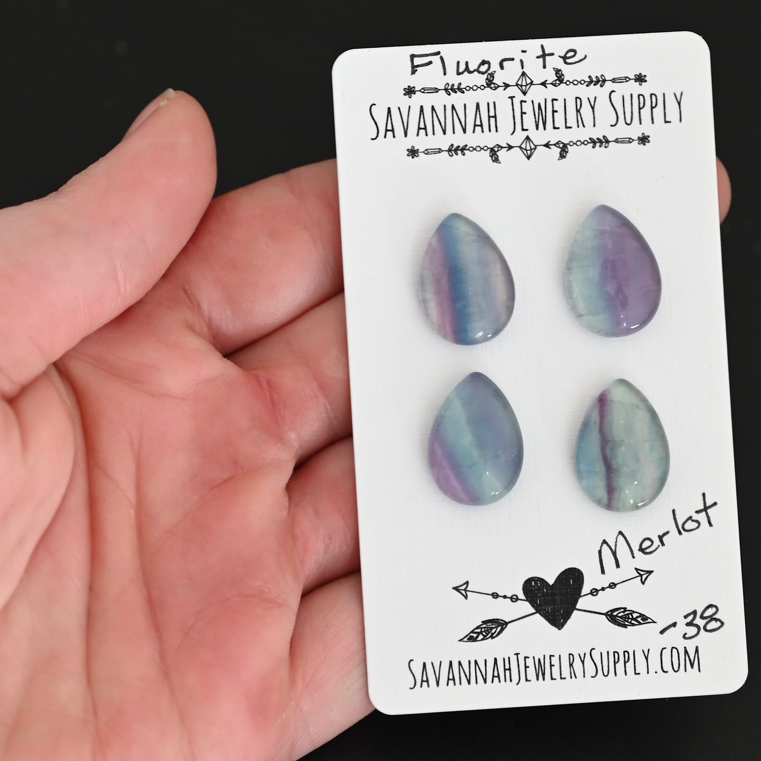 Merlot Fluorite Cabochon Parcel shown in hand