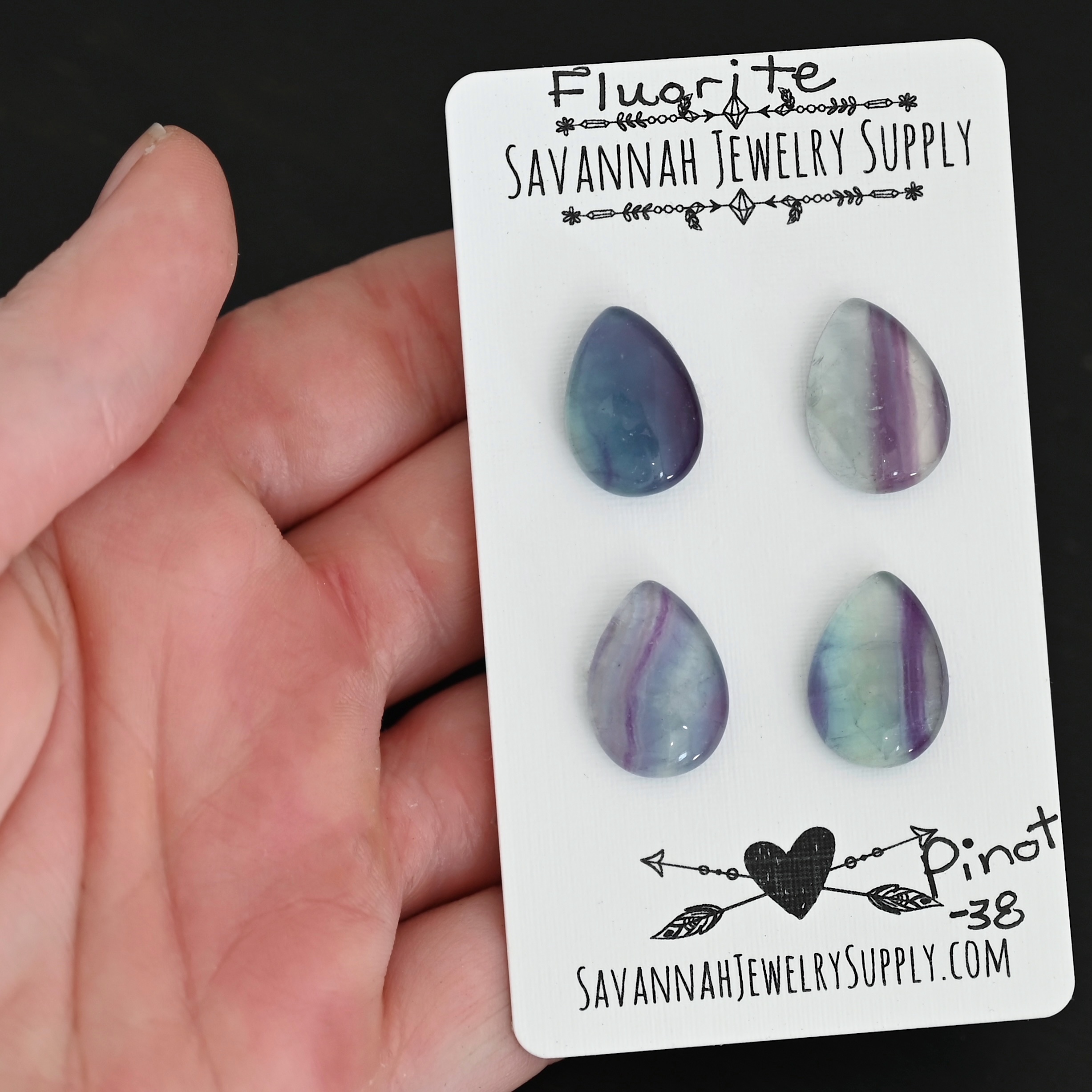 Pinot Fluorite Cabochon Parcel shown in hand