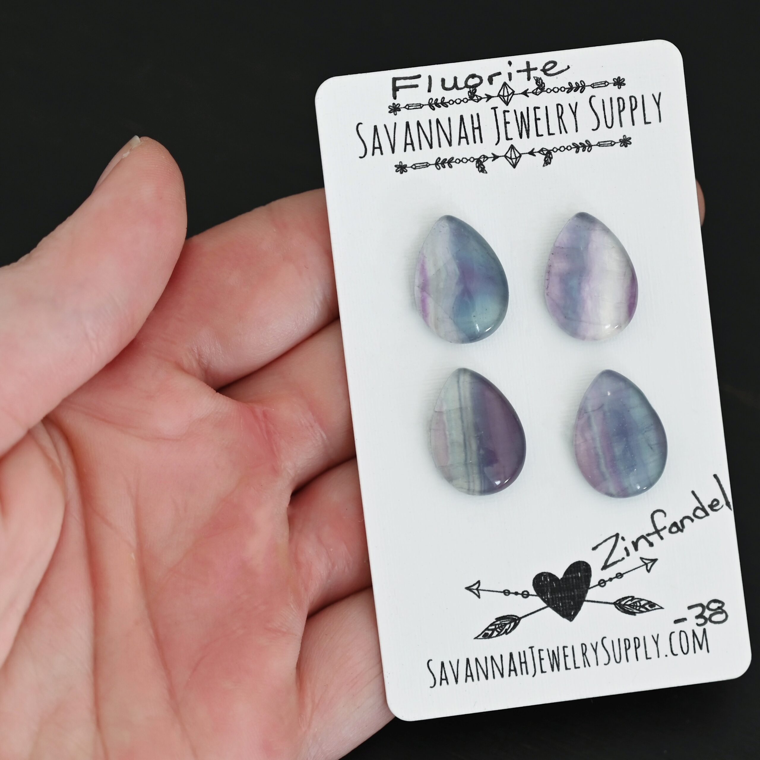 Zinfandel Fluorite Cabochon Parcel shown in hand