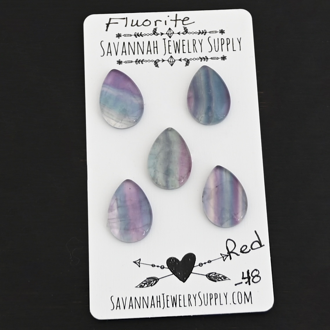 Red Fluorite Cabochon Parcel shown on business card