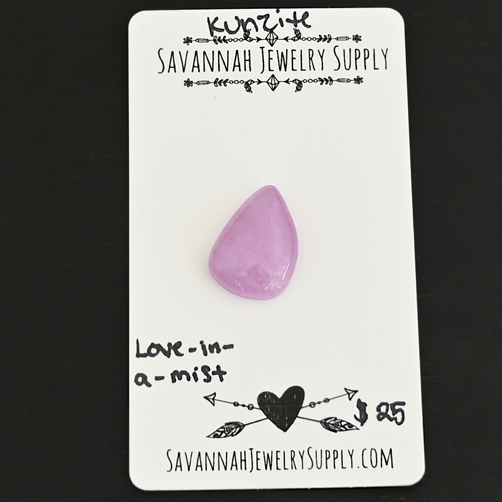 Love-In-A-Mist Kunzite Cabochon Parcel shown on business card