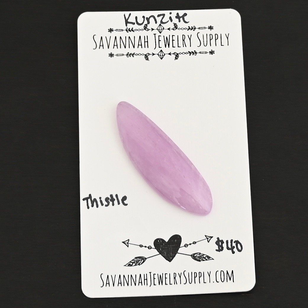 Thistle Flower Kunzite Cabochon Parcel shown on business card