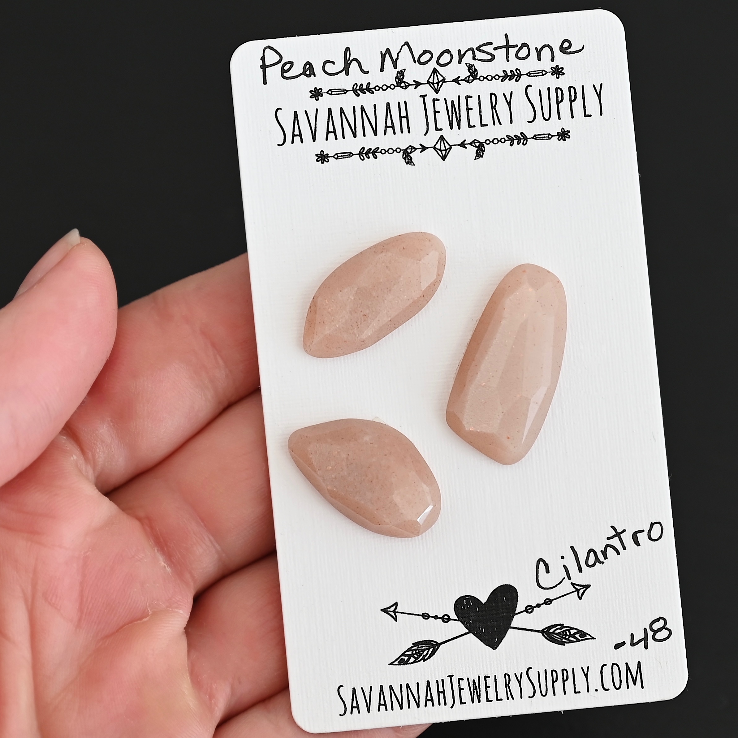 Cilantro Rose Cut Peach Moonstone Cabochon Parcel shown in hand