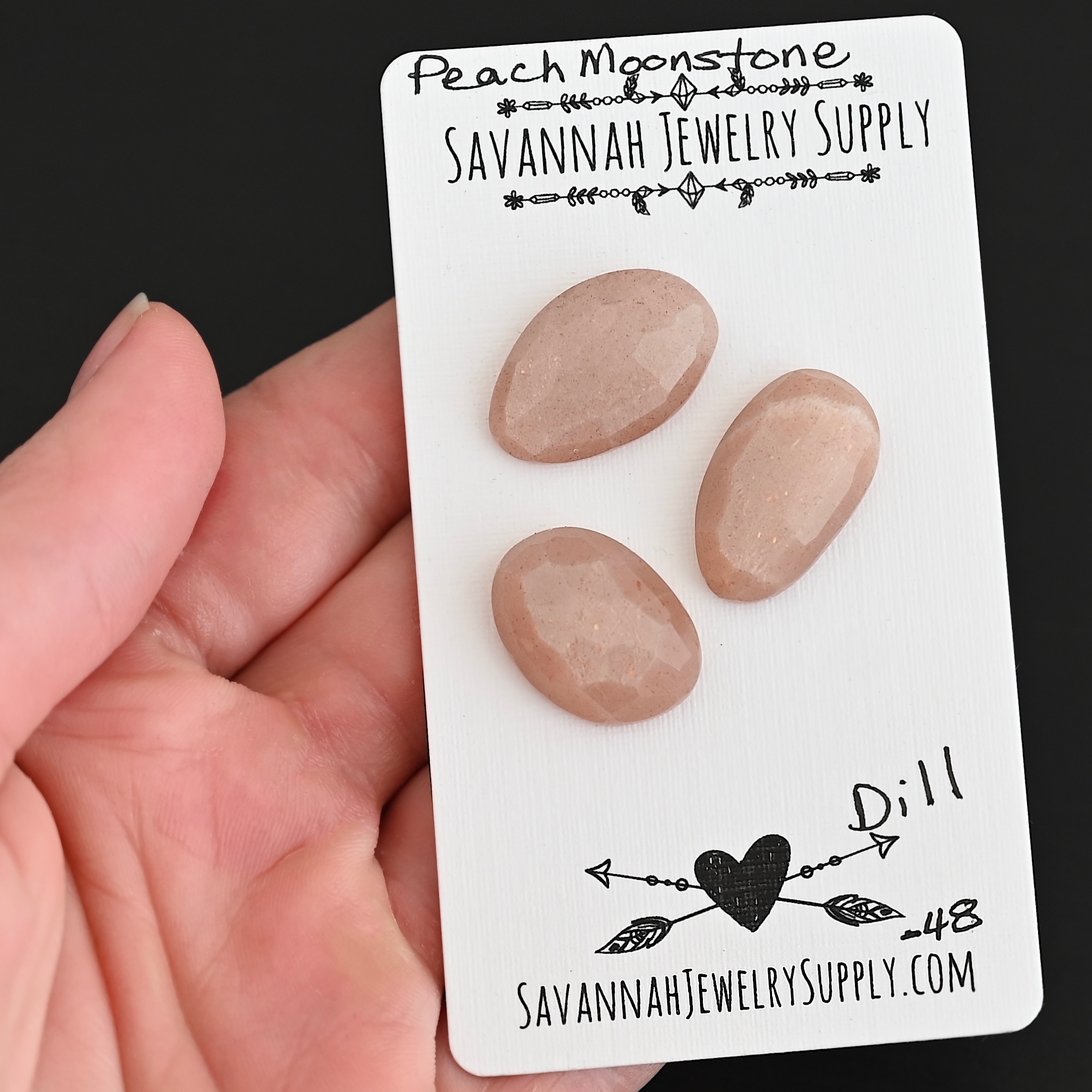 Dill Rose Cut Peach Moonstone Cabochon Parcel shown in hand