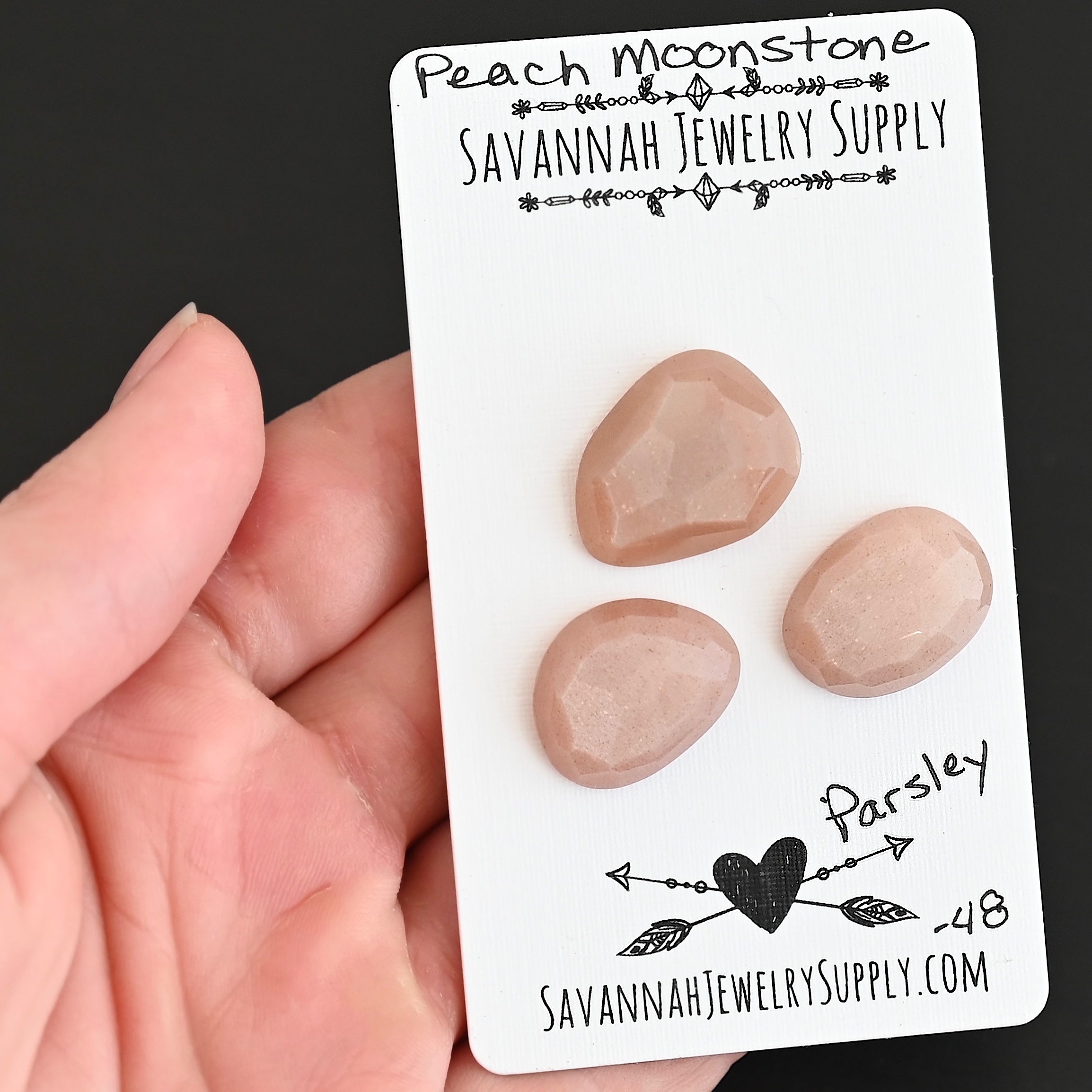 Parsley Rose Cut Peach Moonstone Cabochon Parcel shown in hand