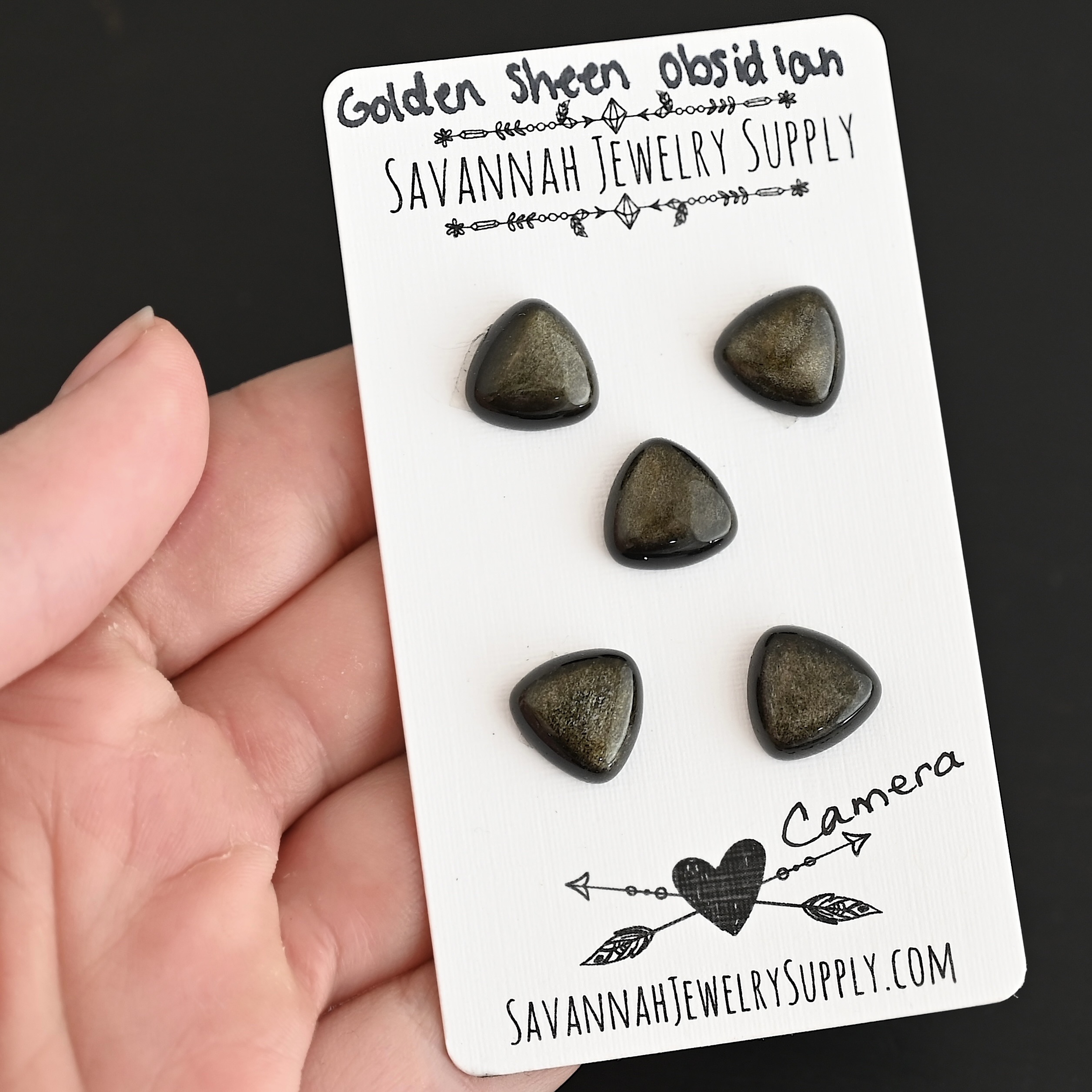 Camera Golden Sheen Obsidian Cabochon Parcel shown in hand