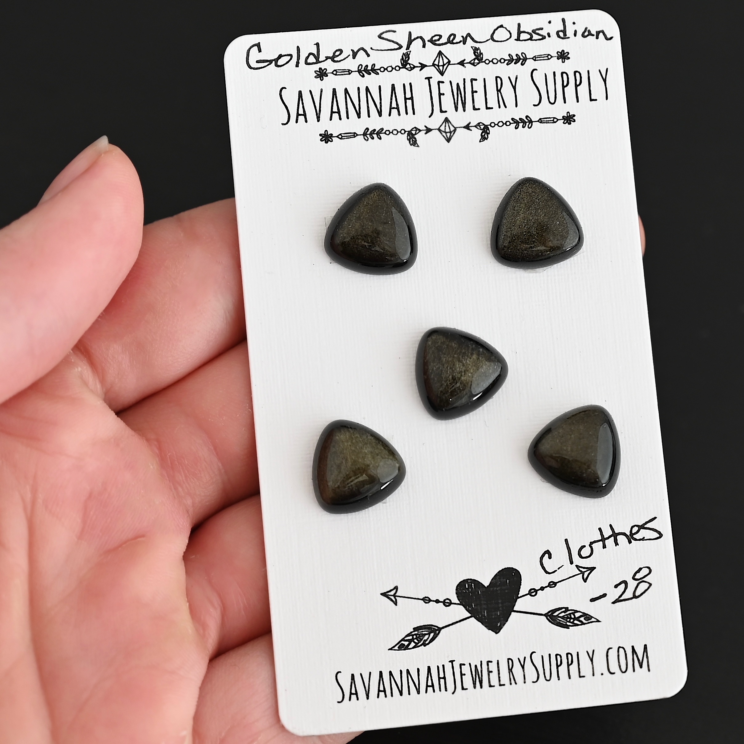 Clothes Golden Sheen Obsidian Cabochon Parcel shown in hand