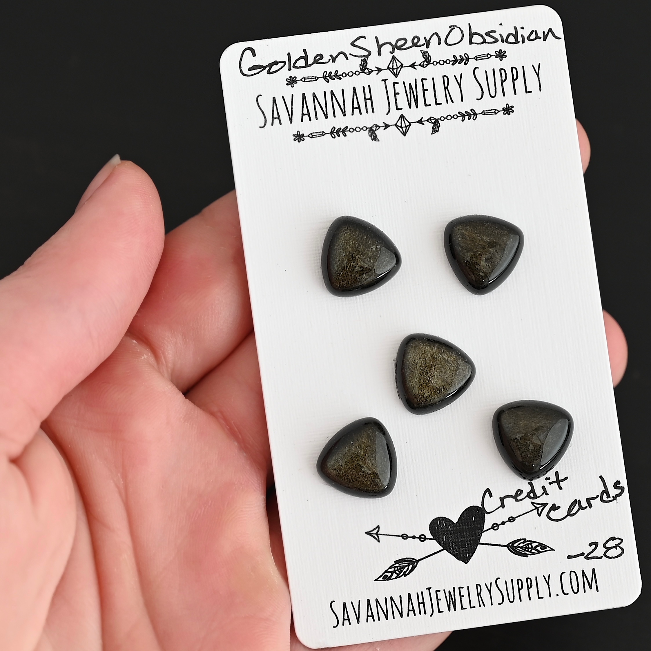 Credit Cards Golden Sheen Obsidian Cabochon Parcel shown in hand