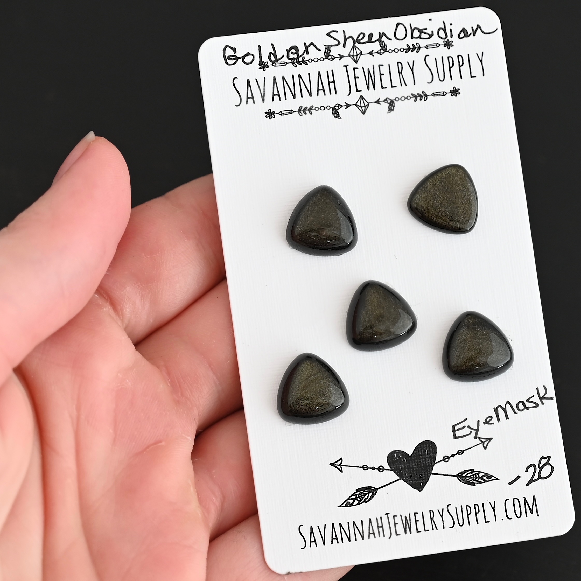 Eye Mask Golden Sheen Obsidian Cabochon Parcel shown in hand
