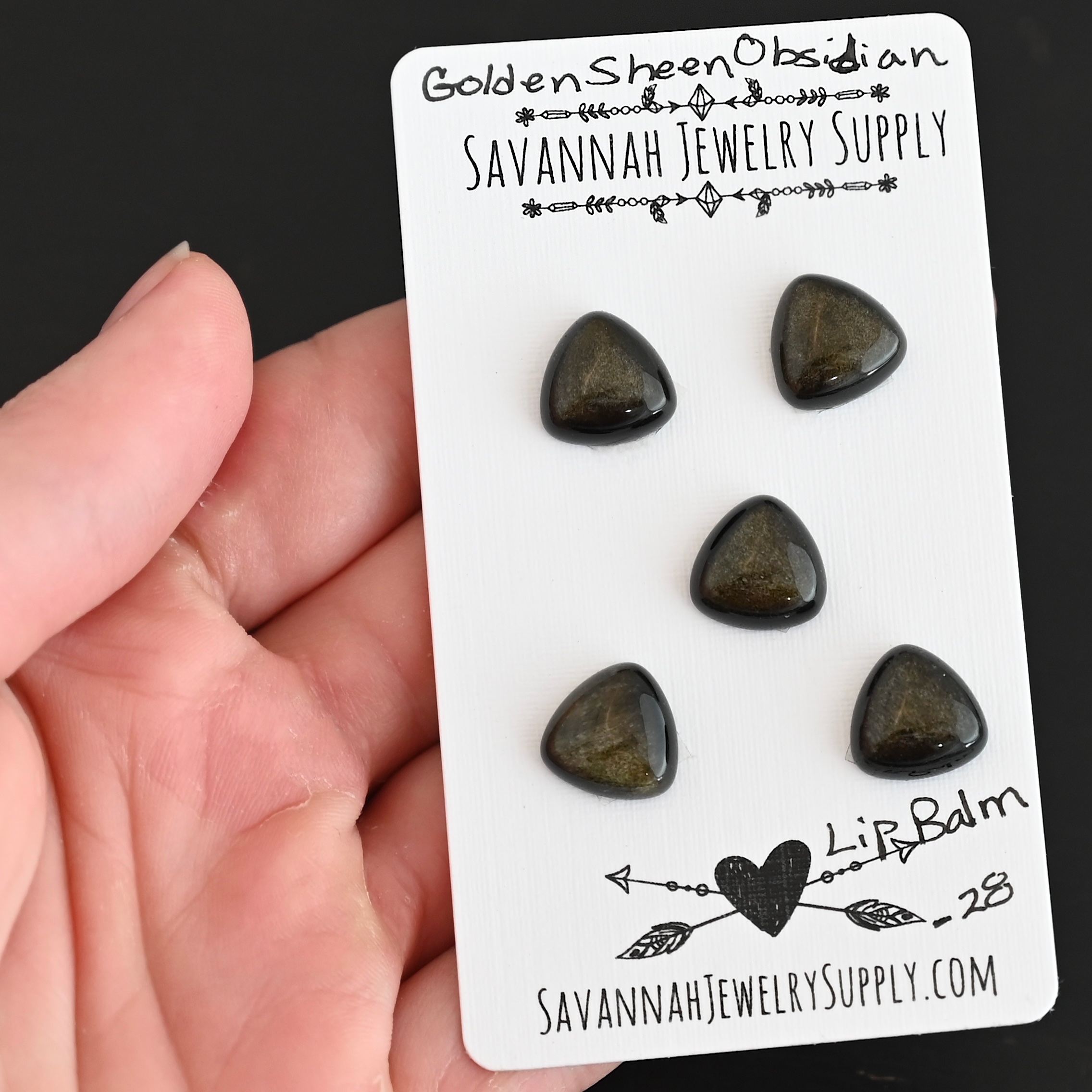 Lip Balm Golden Sheen Obsidian Cabochon Parcel shown in hand