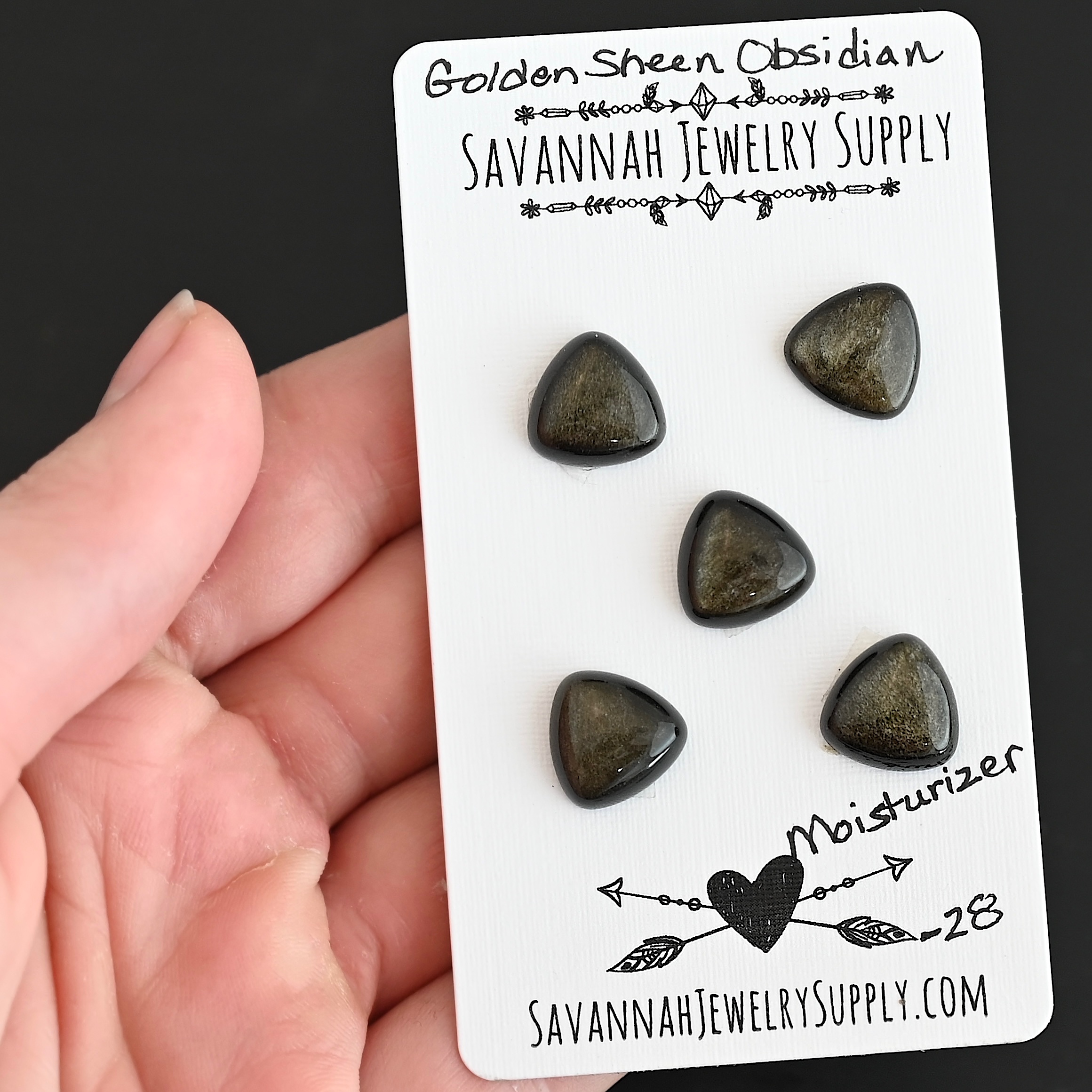 Moisturizer Golden Sheen Obsidian Cabochon Parcel shown in hand