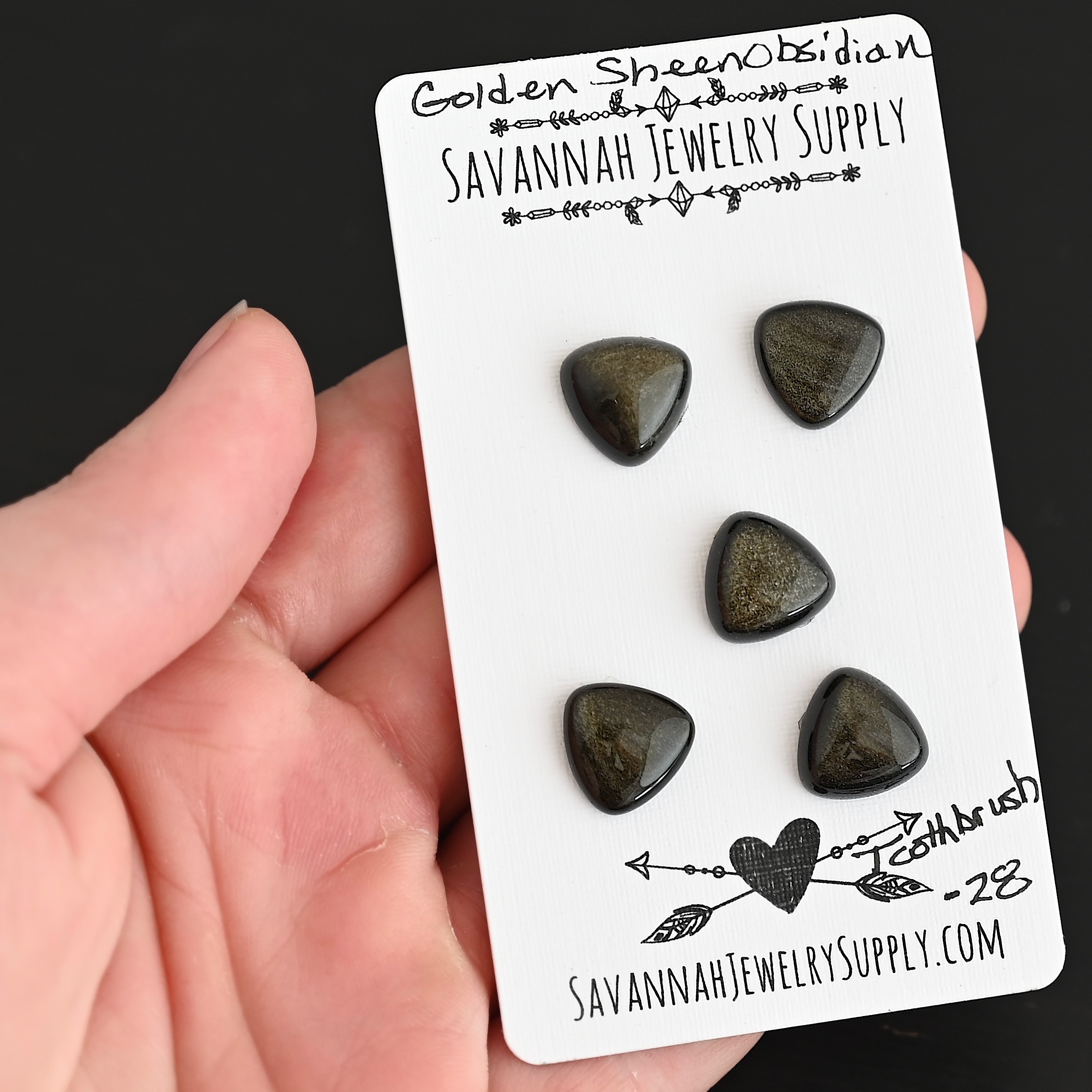 Toothbrush Golden Sheen Obsidian Cabochon Parcel shown in hand