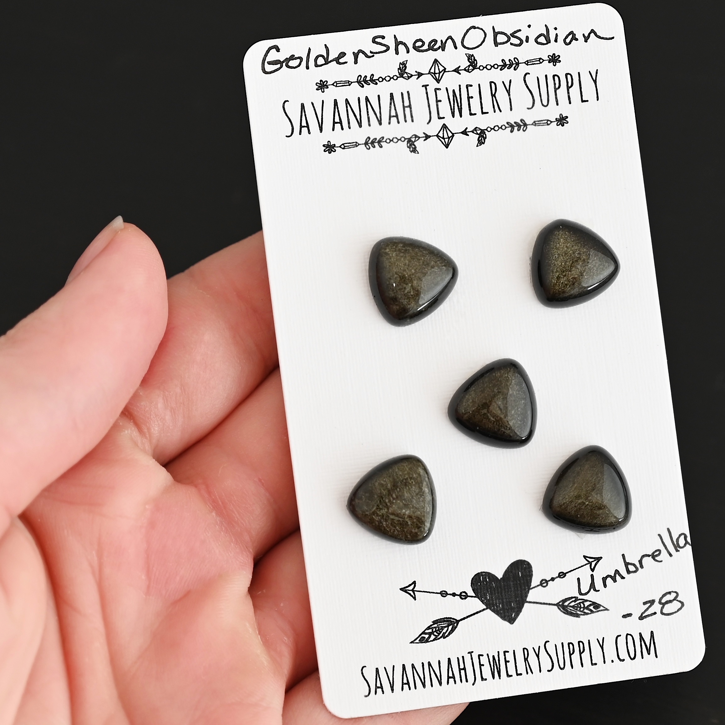 Umbrella Golden Sheen Obsidian Cabochon Parcel shown in hand