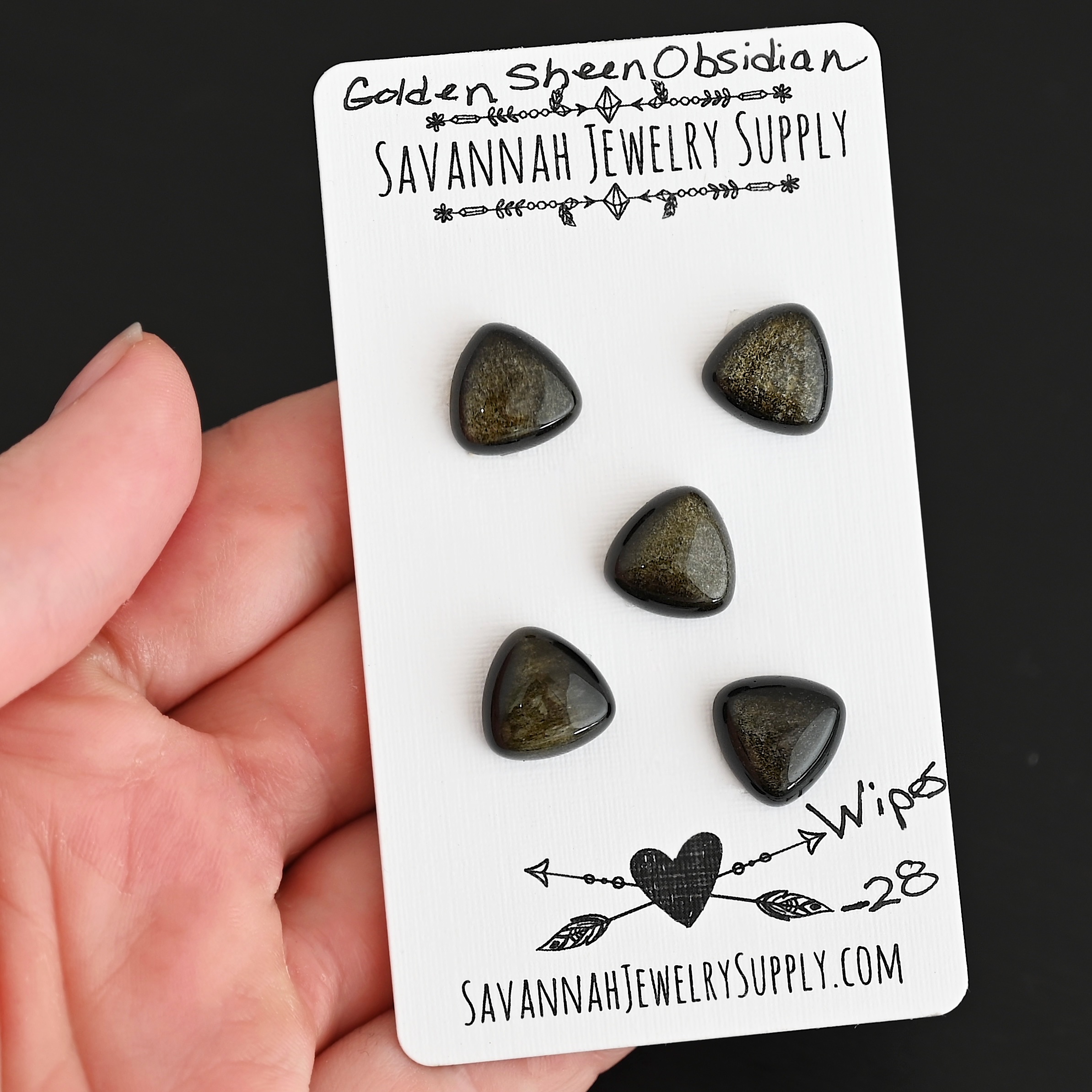 Wipes Golden Sheen Obsidian Cabochon Parcel shown in hand