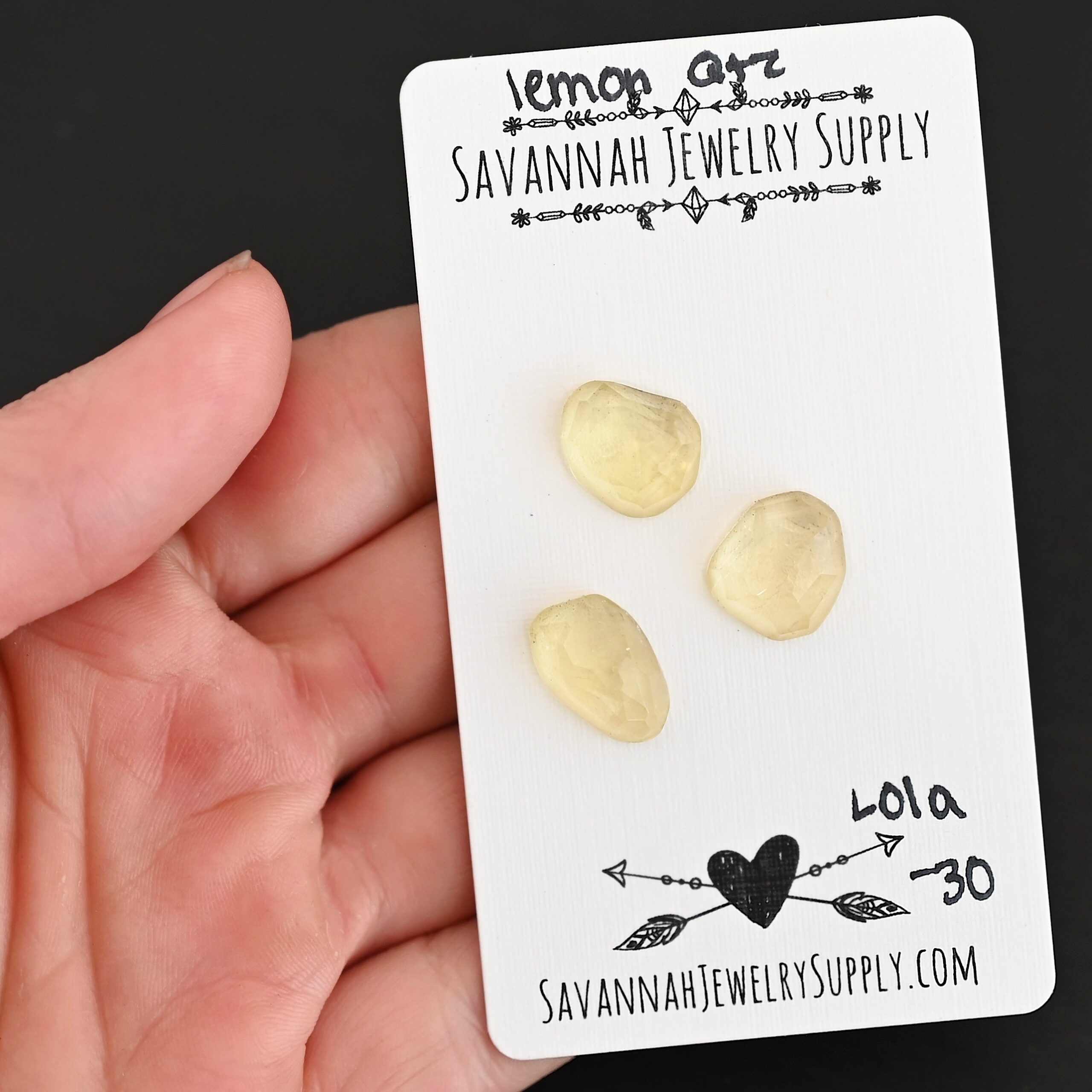 Lola Rose Cut Lemon Quartz Cabochon Parcel shown in hand