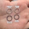 Four jump rings shown in the palm of a hand up close. Two are hammered and two are smooth. Two are shiny and two are oxidized.