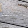 Seven jump rings labeled with mm and going from smallest to largest left to right.