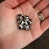 Pile of thick oxidized jump rings lying in the palm of a hand.